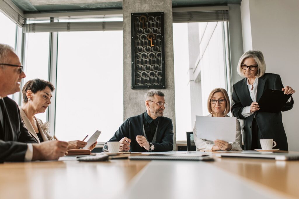 Executive presenting figures in a boardroom. Cover image for Making Marketing's Case Inside the Company.