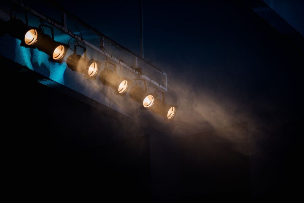 Empty theater stage with a single spotlight. Cover image for Welcoming the Unbidden: A Marketer Trained in the Theater on Whole-Brained Work.
