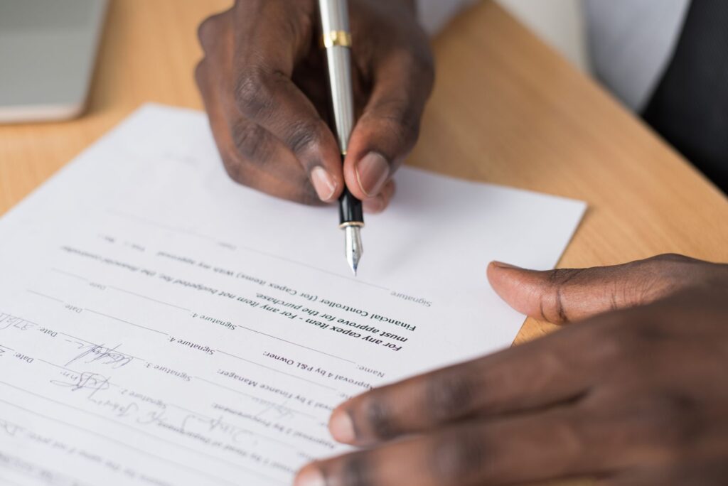 Signing a document with a fountain pen. Cover image for Nobody Took It to the Board: What the Roundtable Signatories Thought They Were Signing.