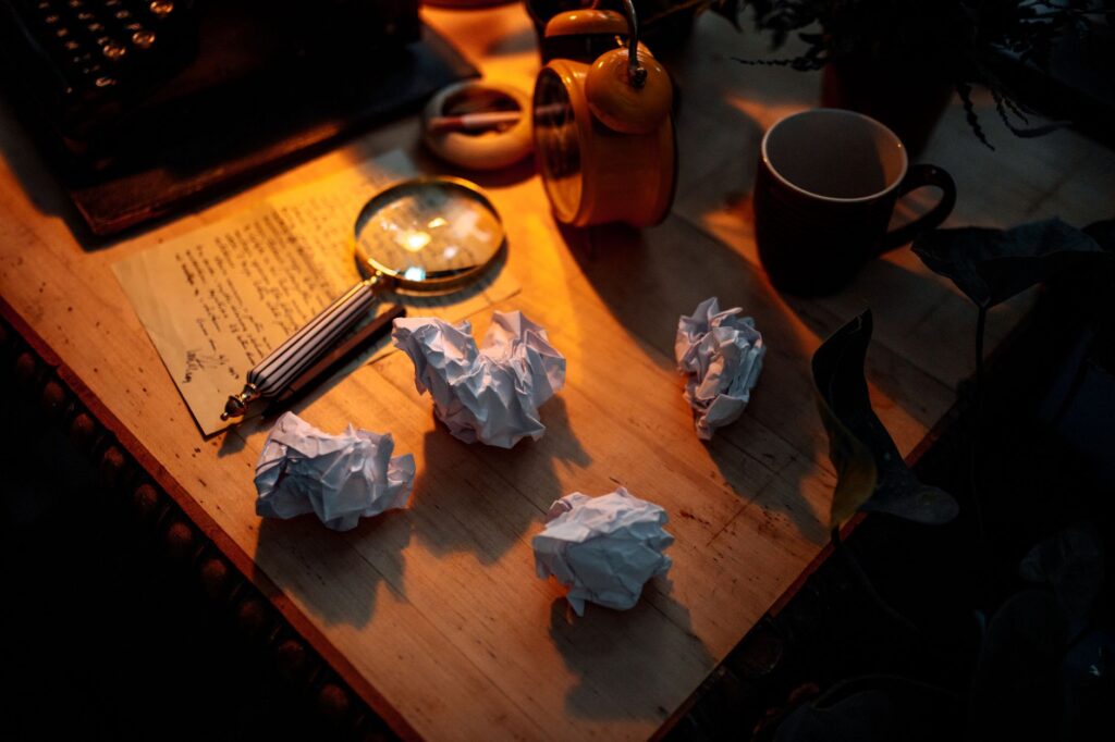 Crumpled paper drafts scattered on a desk. Cover image for Ten Versions Before the Right One: Writing a Purpose for a Company Not Yet Born.
