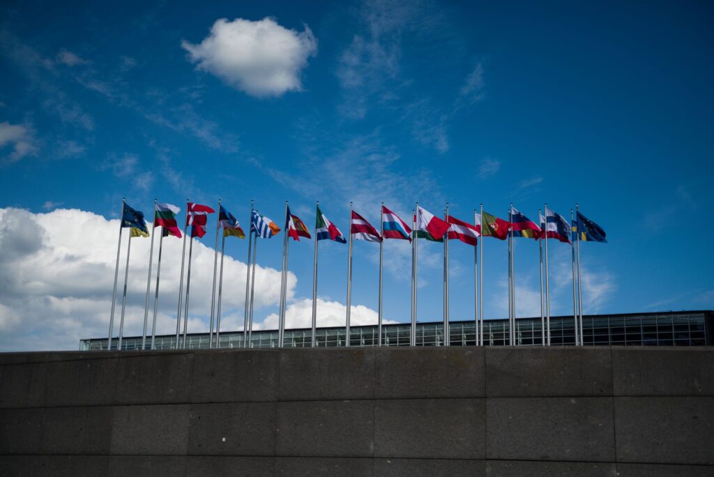 Row of international flags against the sky. Cover image for Not a CSR Organization: What the UN Global Compact Actually Asks of a Company.
