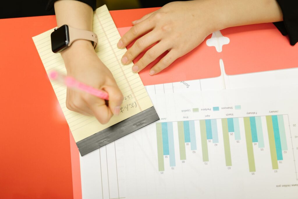 Printed charts and handwritten notes on a table. Cover image for The Numbers Say Pay Attention. The Words Say to What..