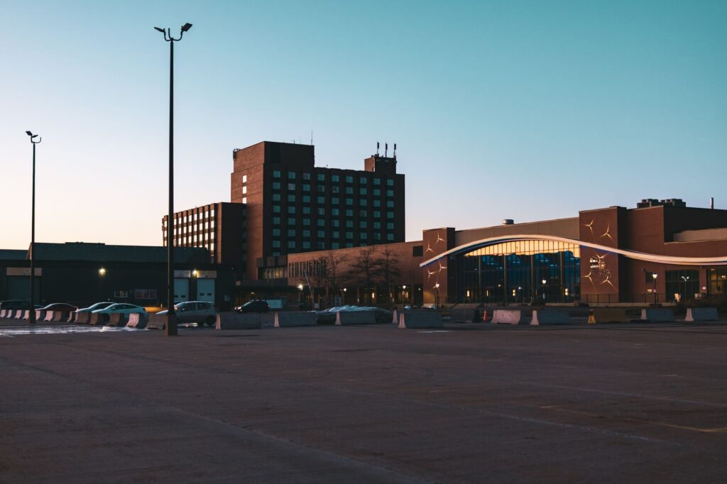 Empty parking lot at dusk. Cover image for The Invisible Law, and a Pile of Trash in the Parking Lot.