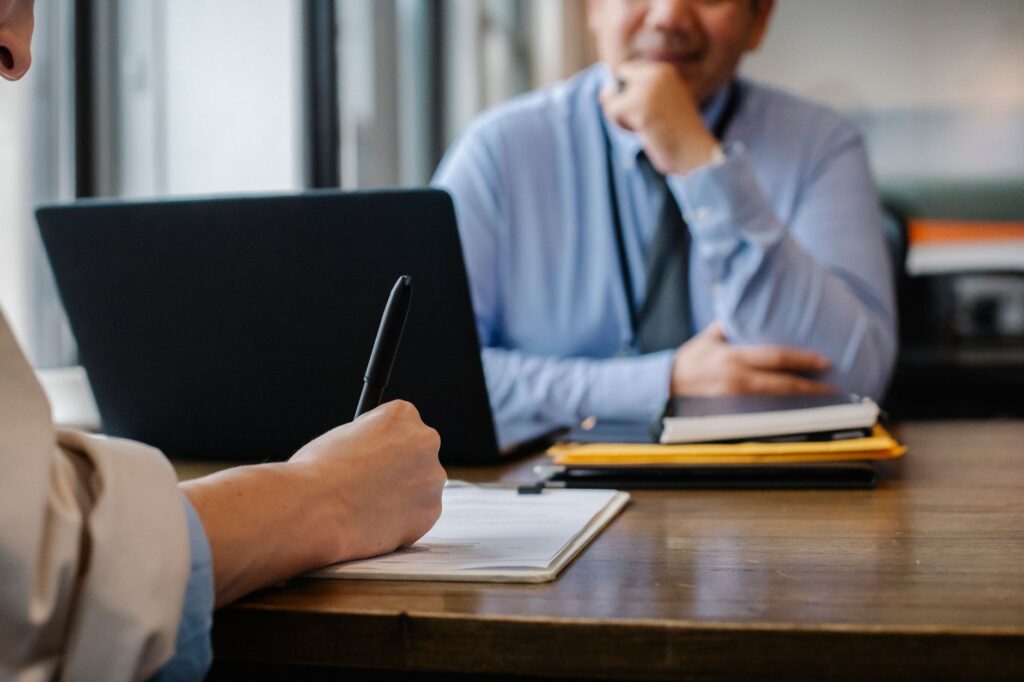 Job candidate interview across an office desk. Cover image for Poets and Plumbers: The Search Consultant Who Named the Da Vinci CMO.