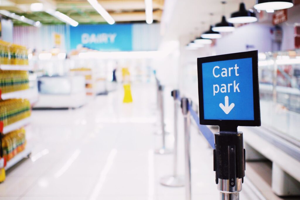 Modern drugstore aisle with shelves of products. Cover image for Fewer Ten-Packs, More Ten-Million-Dollar Deals: How CVS Paid for Leaving Tobacco.